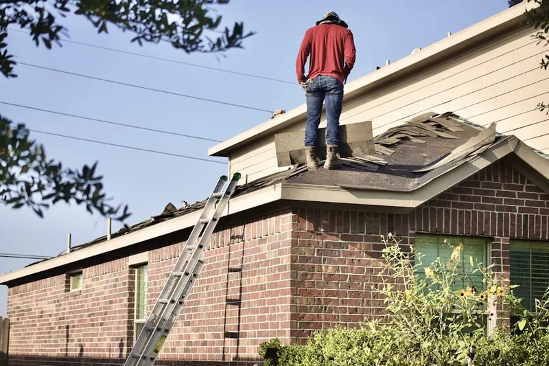 Professional roofer working on a residential roof in Frush Valley